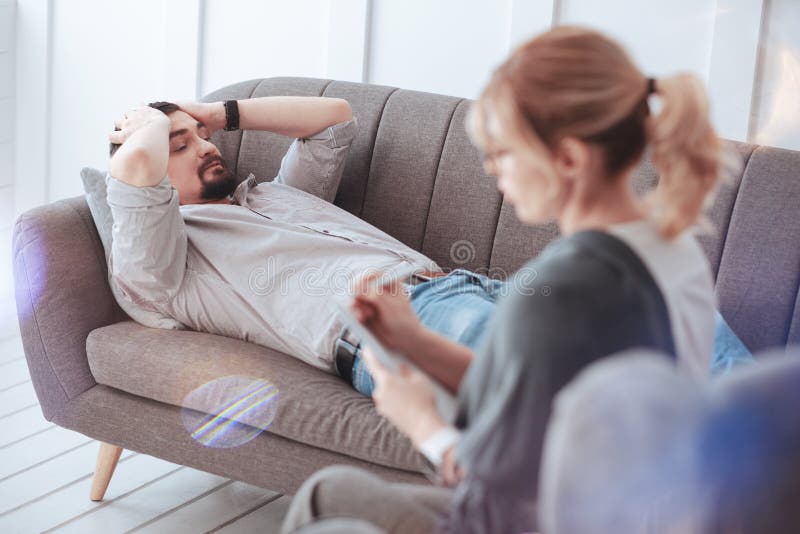 Moody cheerless man suffering from depression. I need help. Moody unhappy cheerless men having lots of problems and visiting a psychologist while suffering from depression