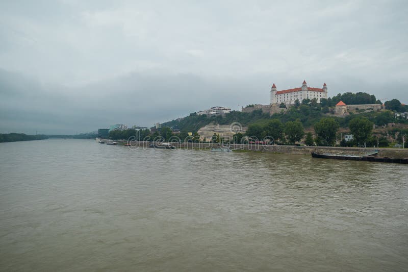 Náladové panorama Bratislavy při pohledu z Nového mostu směrem k hradu přes řeku za nudného šedého dne