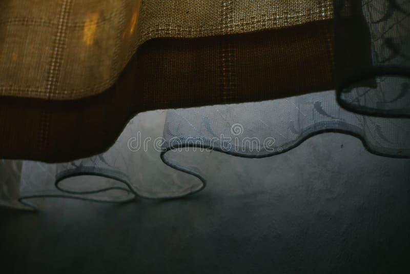 Moody still life of yellow curtain and drapes on the bedroom window