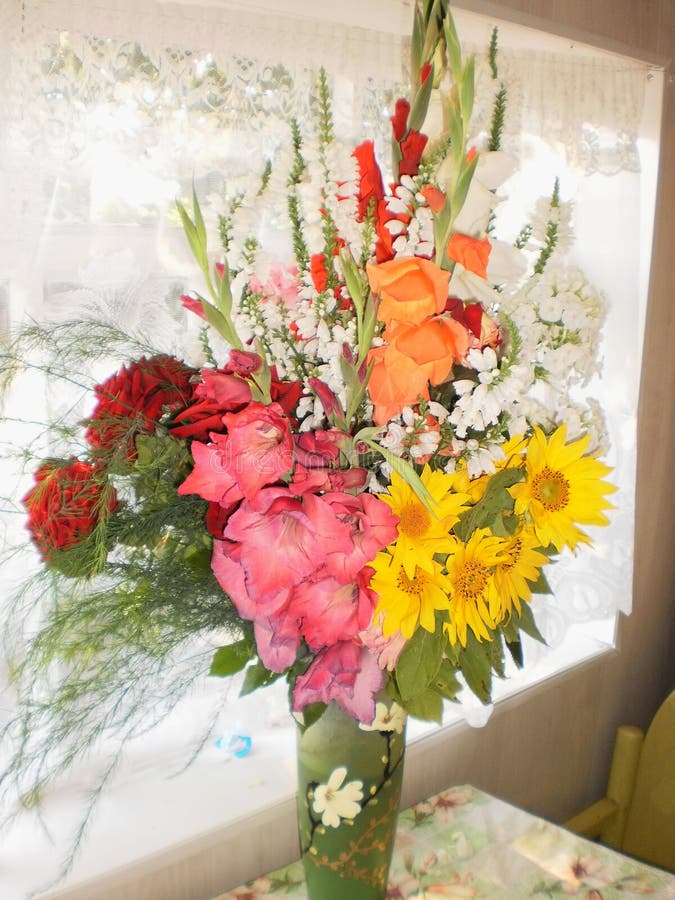 Mooi boeket van gladioli, rozen en bloemen van een zonnebloem, een vaas van bloemen royalty-vrije stock afbeeldingen Mooi boeket van gladioli, rozen en bloemen van een zonnebloem, een vaas van bloemen royalty-vrije stock afbeeldingen