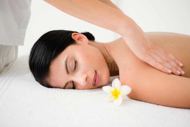 Mooi brunette die van een massage ruikende bloem genieten bij camera royalty-vrije stock afbeelding Mooi brunette die van een massage ruikende bloem genieten bij camera royalty-vrije stock afbeelding