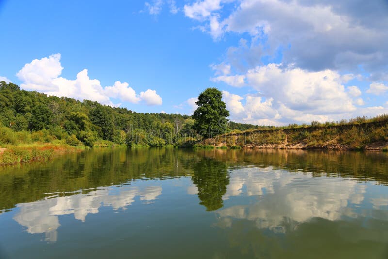 Download Mooi De Zomerlandschap De Boom En De Blauwe Hemel Worden Weerspiegeld In Het Water Stock Foto - Afbeelding bestaande uit vrede, ochtend: 107700704