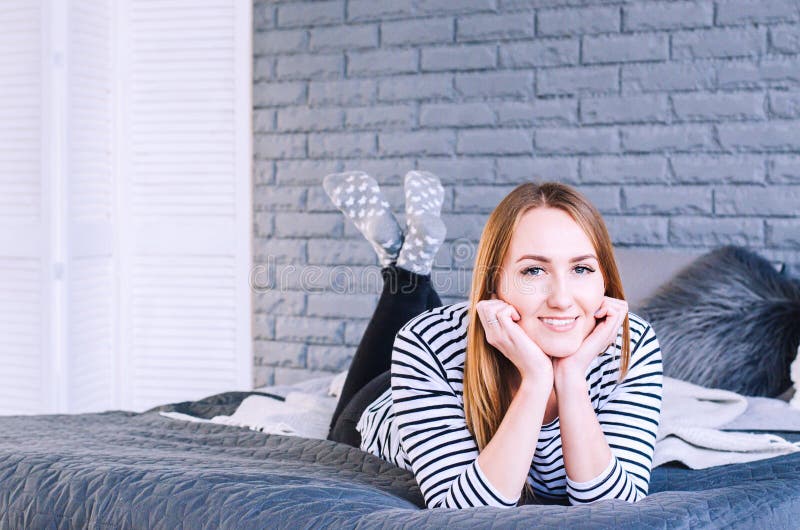 Mooi glimlachend meisje die op het bed liggen royalty-vrije stock afbeeldingen Mooi glimlachend meisje die op het bed liggen royalty-vrije stock afbeeldingen