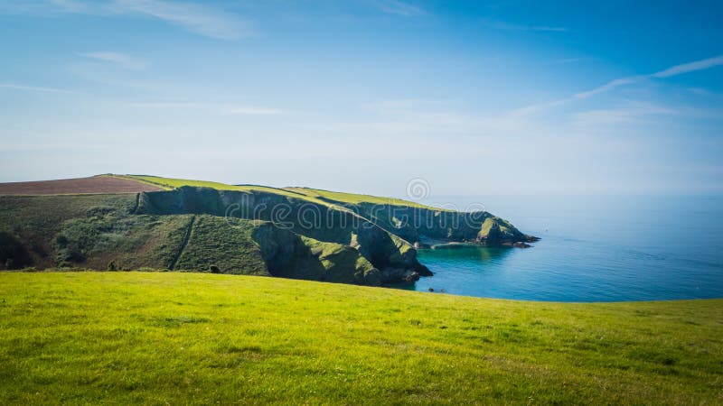 Mooi groen klippenlandschap door de Atlantische Oceaan dichtbij Postisaac in Cornwall, het UK stock afbeelding Mooi groen klippenlandschap door de Atlantische Oceaan dichtbij Postisaac in Cornwall, het UK stock afbeelding