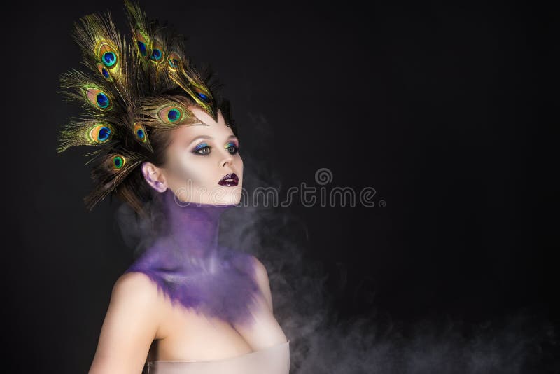 Mooi groot borstmeisje die pauwveren in haar haar a dragen stock foto Mooi groot borstmeisje die pauwveren in haar haar a dragen stock foto