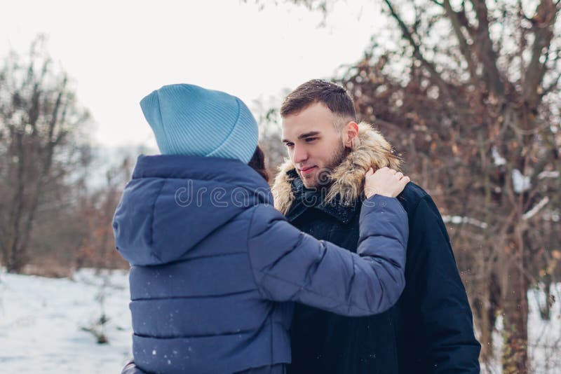 Mooi houdend van paar die en in de winter bosmensen lopen koesteren die in openlucht koelen royalty-vrije stock fotografie Mooi houdend van paar die en in de winter bosmensen lopen koesteren die in openlucht koelen royalty-vrije stock fotografie