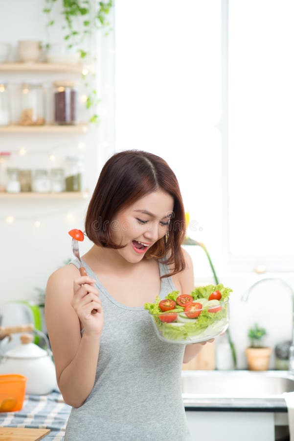 Mooi jong Aziatisch meisje die salade eten royalty-vrije stock afbeelding Mooi jong Aziatisch meisje die salade eten royalty-vrije stock afbeelding