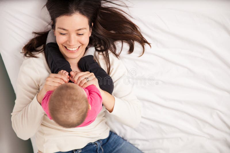 Mooi mamma en haar babydochter in een bed stock fotografie Mooi mamma en haar babydochter in een bed stock fotografie