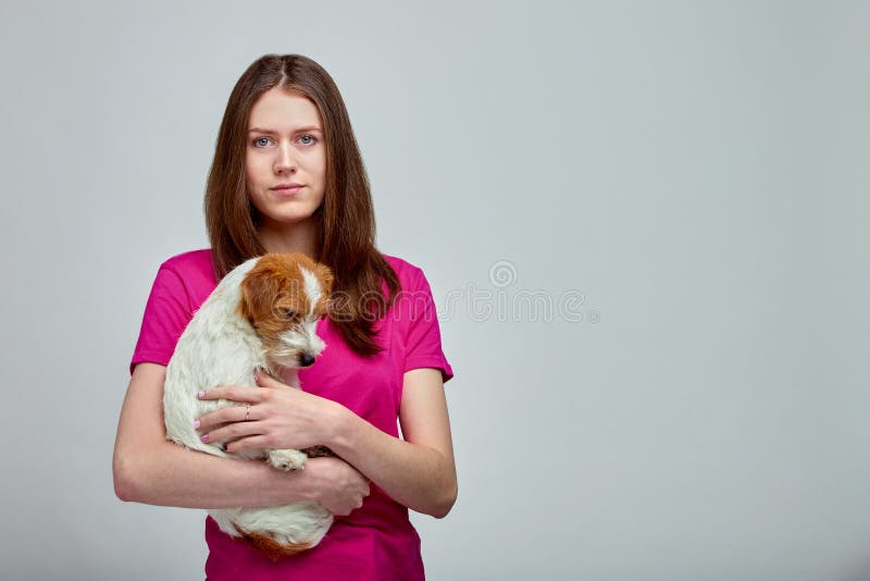 Mooi meisje die een hond door Jack Russell-terriër op handen op grijze achtergrond, exemplaarruimte, Greenpeace koesteren cocept royalty-vrije stock foto's Mooi meisje die een hond door Jack Russell-terriër op handen op grijze achtergrond, exemplaarruimte, Greenpeace koesteren cocept royalty-vrije stock foto's