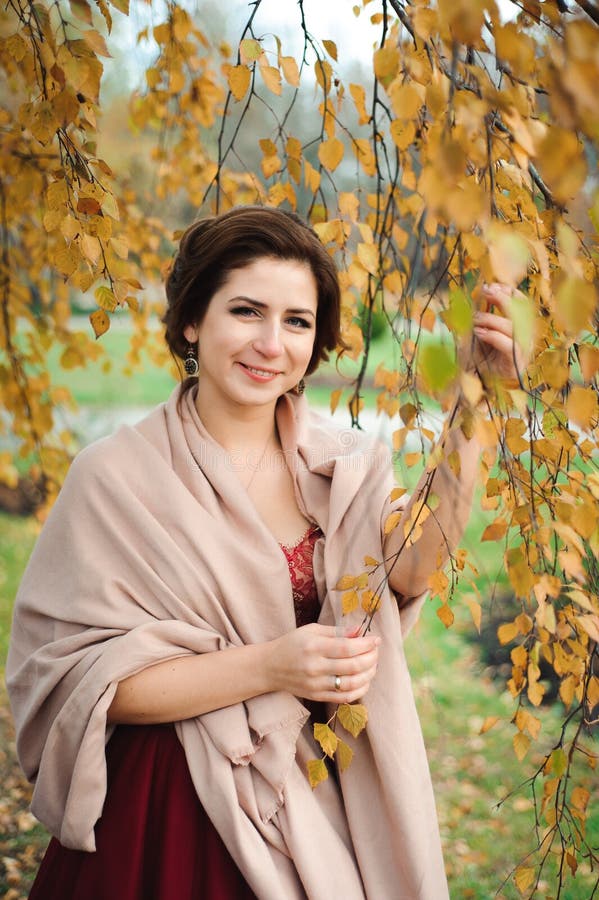Mooi meisje in een rode kleding in het de herfstbos royalty-vrije stock fotografie Mooi meisje in een rode kleding in het de herfstbos royalty-vrije stock fotografie