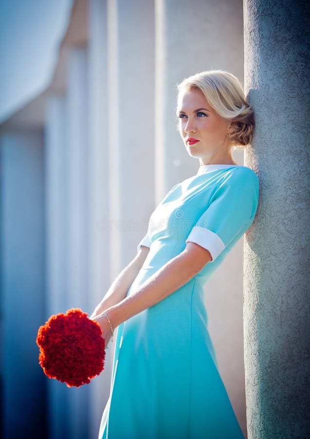 Mooi meisje in een roze kleding met een boeket van royalty-vrije stock afbeelding Mooi meisje in een roze kleding met een boeket van royalty-vrije stock afbeelding