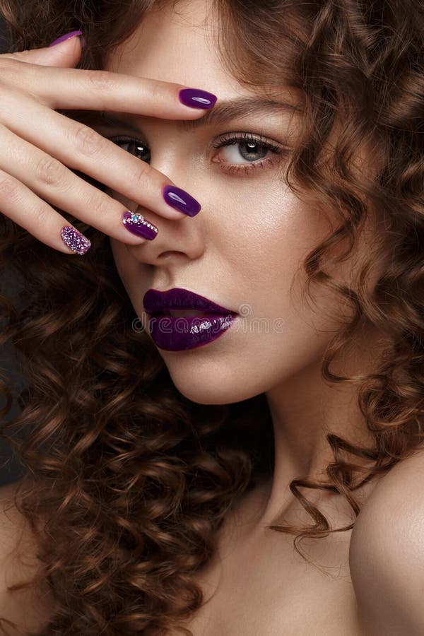 Mooi meisje met avondsamenstelling, purpere lippen, krullen en de spijkers van de ontwerpmanicure Het Gezicht van de schoonheid royalty-vrije stock afbeeldingen Mooi meisje met avondsamenstelling, purpere lippen, krullen en de spijkers van de ontwerpmanicure Het Gezicht van de schoonheid royalty-vrije stock afbeeldingen