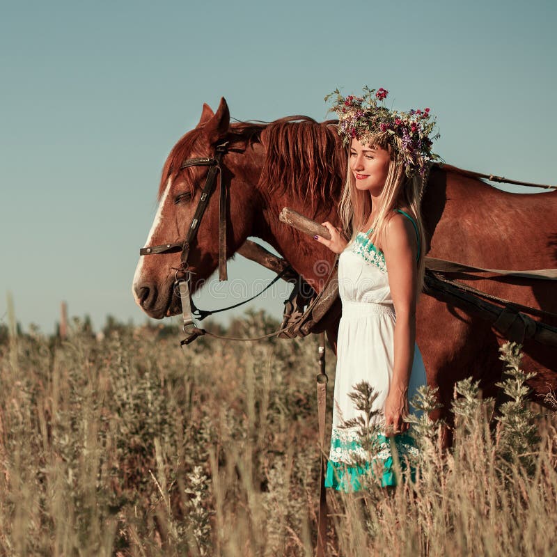 Mooi meisje met wildflowers op het paardvervoer in de zomerdag royalty-vrije stock afbeeldingen Mooi meisje met wildflowers op het paardvervoer in de zomerdag royalty-vrije stock afbeeldingen