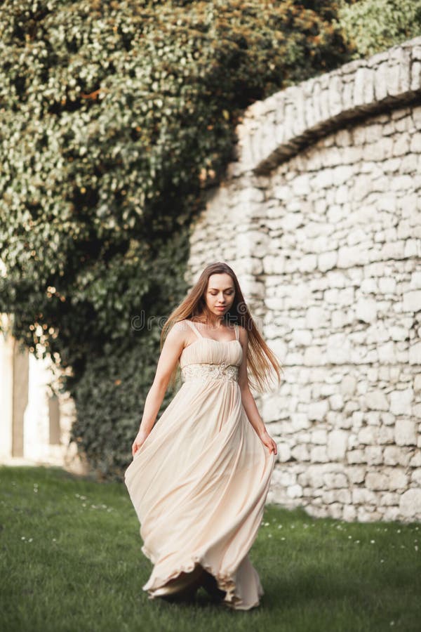 Mooi meisje, model met het lange haar stellen in park dichtbij grote muur Krakau Vavel stock foto Mooi meisje, model met het lange haar stellen in park dichtbij grote muur Krakau Vavel stock foto