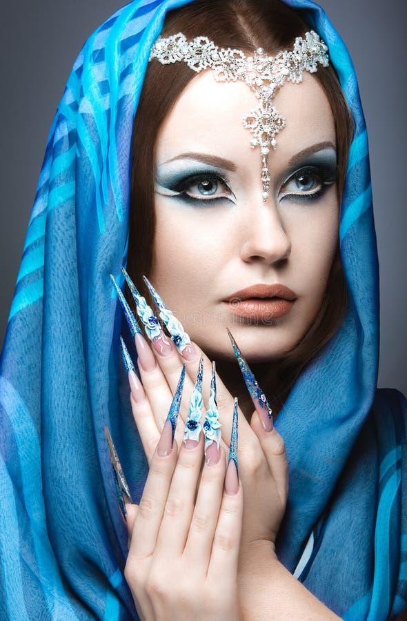 Mooi meisje in oostelijk Arabisch beeld met lange spijkers en heldere blauwe samenstelling stock afbeeldingen Mooi meisje in oostelijk Arabisch beeld met lange spijkers en heldere blauwe samenstelling stock afbeeldingen