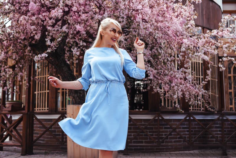 Mooi model in blauwe kleding door de lente bloeiende boom royalty-vrije stock foto Mooi model in blauwe kleding door de lente bloeiende boom royalty-vrije stock foto