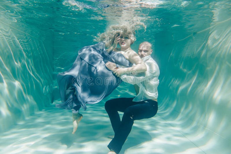 Mooi romantisch paar van minnaars die zacht onder water koesteren stock fotografie Mooi romantisch paar van minnaars die zacht onder water koesteren stock fotografie