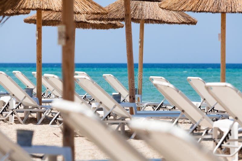 Mooi strand met ligstoelen en paraplu's royalty-vrije stock afbeeldingen Mooi strand met ligstoelen en paraplu's royalty-vrije stock afbeeldingen