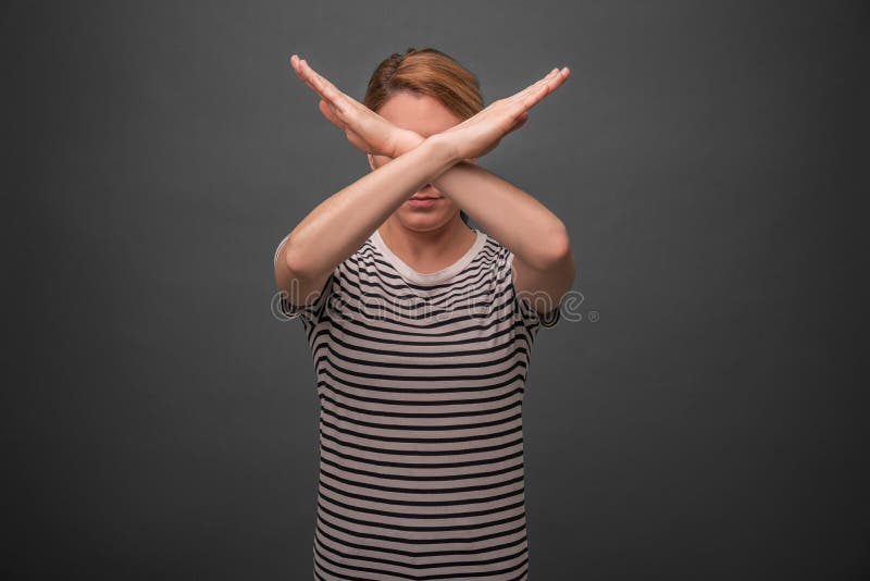 Mooi te kruisen de handenkruis van de vrouwenholding Protest of verbod op grijze achtergrond stock afbeelding Mooi te kruisen de handenkruis van de vrouwenholding Protest of verbod op grijze achtergrond stock afbeelding