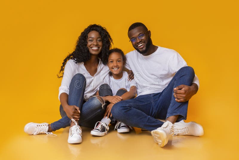 Mooie afrikaanse familie zit op de vloer en lacht