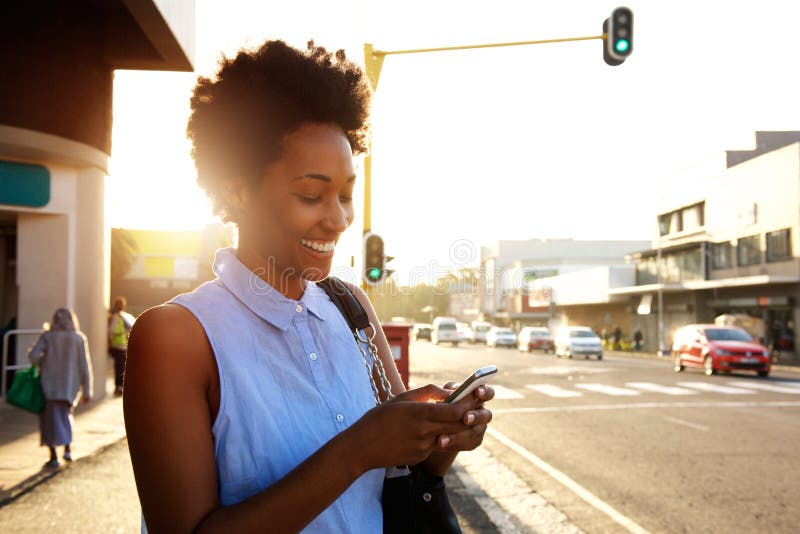 Mooie Afrikaanse vrouw die cellphone in openlucht gebruiken stock afbeelding Mooie Afrikaanse vrouw die cellphone in openlucht gebruiken stock afbeelding