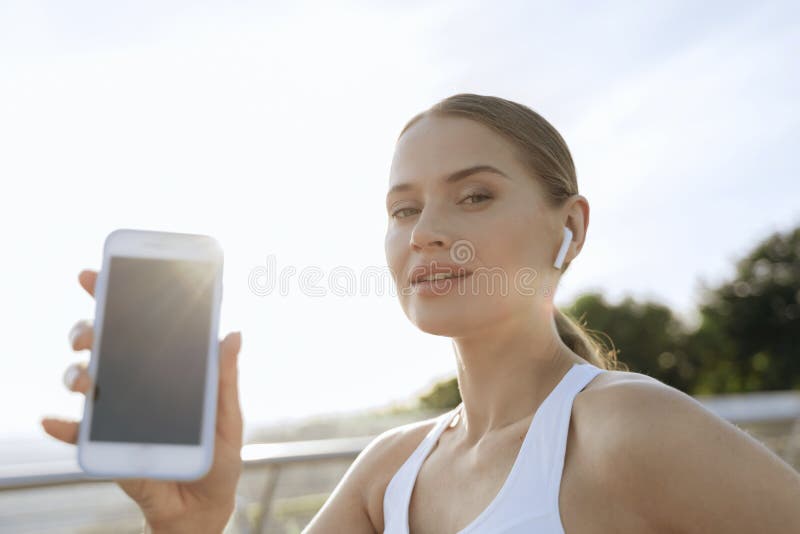Mooie atletische dame die mobiele telefoon laat zien royalty-vrije stock fotografie Mooie atletische dame die mobiele telefoon laat zien royalty-vrije stock fotografie