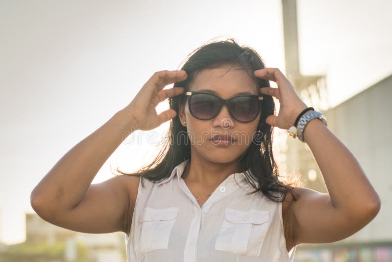 Mooie Aziatische dame die in zonnebril in de camera kijken stock fotografie Mooie Aziatische dame die in zonnebril in de camera kijken stock fotografie