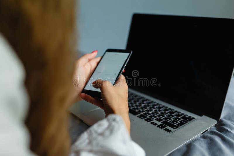 Mooie blondevrouw die met haar smartphone telefoneren die op haar bed naast haar notitieboekje liggen Meisje die op bed liggen di royalty-vrije stock afbeelding Mooie blondevrouw die met haar smartphone telefoneren die op haar bed naast haar notitieboekje liggen Meisje die op bed liggen di royalty-vrije stock afbeelding