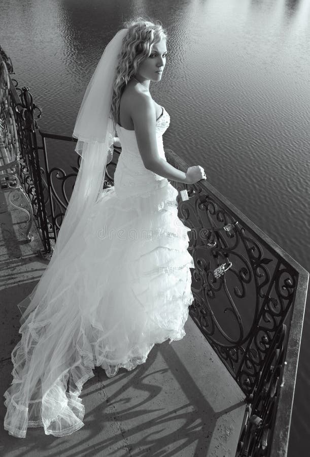 Beautiful caucasian bride standing on bridge. Beautiful caucasian bride standing on bridge