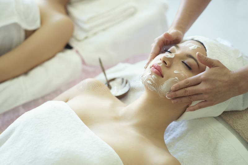 Beautiful caucasian woman cleaning makeup before massage and making facial mask treatment on face in Spa salon. Beautiful caucasian woman cleaning makeup before massage and making facial mask treatment on face in Spa salon.