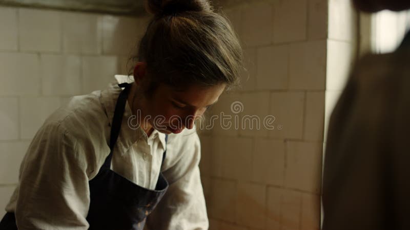 Mooie dame die handwerk maakt in aardewerk. man die vrouw controleert in de werkplaats