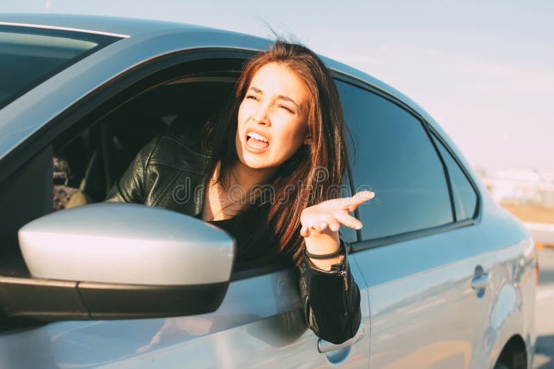Mooie donkerbruine lange haar boze jonge Aziatische vrouw die en in auto drijven gillen stock afbeelding Mooie donkerbruine lange haar boze jonge Aziatische vrouw die en in auto drijven gillen stock afbeelding