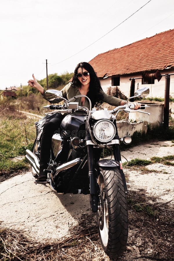 Mooie donkerbruine vrouw met een klassieke motorfiets c royalty-vrije stock afbeelding Mooie donkerbruine vrouw met een klassieke motorfiets c royalty-vrije stock afbeelding