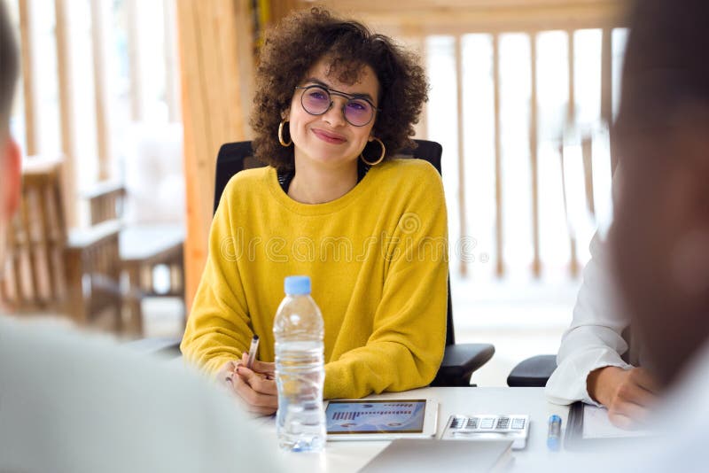 Mooie hipsteronderneemster die aandacht besteden aan haar partners bij het coworking van plaats royalty-vrije stock afbeelding Mooie hipsteronderneemster die aandacht besteden aan haar partners bij het coworking van plaats royalty-vrije stock afbeelding