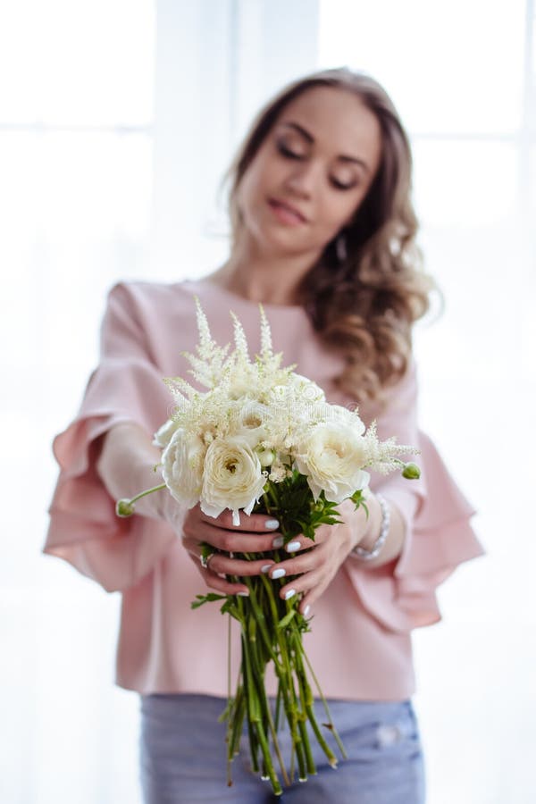 Mooie jonge blondevrouw met boeket van witte bloemen Portret van mooi blondemeisje in roze kleren royalty-vrije stock foto's Mooie jonge blondevrouw met boeket van witte bloemen Portret van mooi blondemeisje in roze kleren royalty-vrije stock foto's