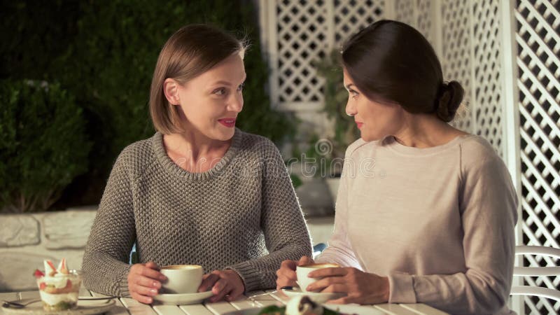 Mooie jonge dames die in koffie, vrouwelijke vrienden spreken die tijd samen doorbrengen royalty-vrije stock foto Mooie jonge dames die in koffie, vrouwelijke vrienden spreken die tijd samen doorbrengen royalty-vrije stock foto