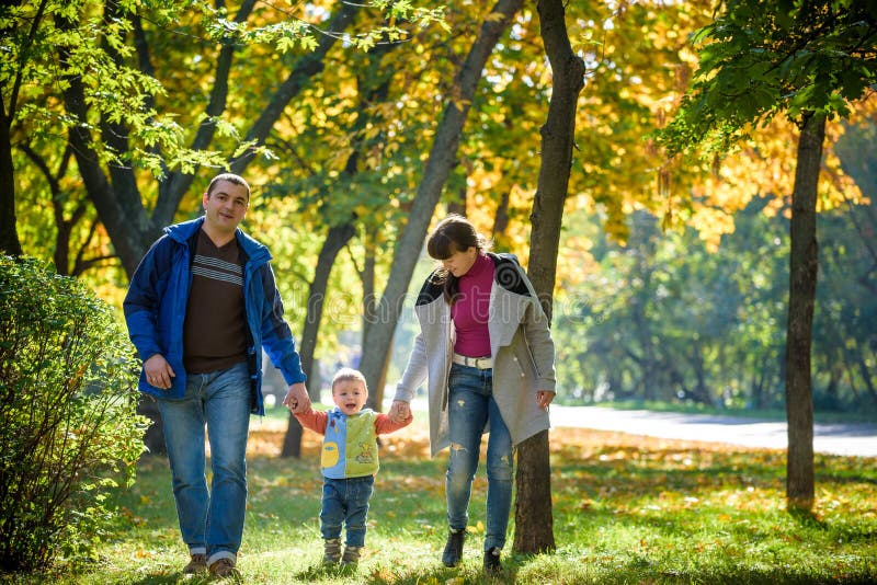 Mooie jonge familie op een gang in de herfstbos op esdoornyello royalty-vrije stock afbeeldingen Mooie jonge familie op een gang in de herfstbos op esdoornyello royalty-vrije stock afbeeldingen