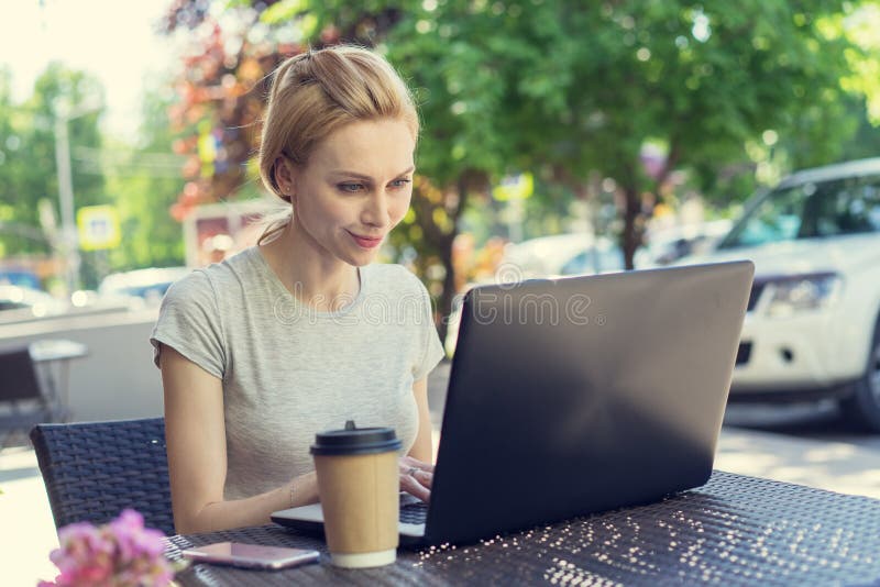 Mooie jonge freelancer Kaukasische vrouw die laptop computerzitting gebruiken bij koffie Gelukkig glimlachend blondemeisje online stock afbeeldingen Mooie jonge freelancer Kaukasische vrouw die laptop computerzitting gebruiken bij koffie Gelukkig glimlachend blondemeisje online stock afbeeldingen