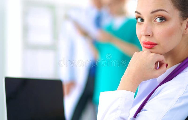 Mooie jonge het glimlachen vrouwelijke artsenzitting bij het bureau stock afbeeldingen Mooie jonge het glimlachen vrouwelijke artsenzitting bij het bureau stock afbeeldingen