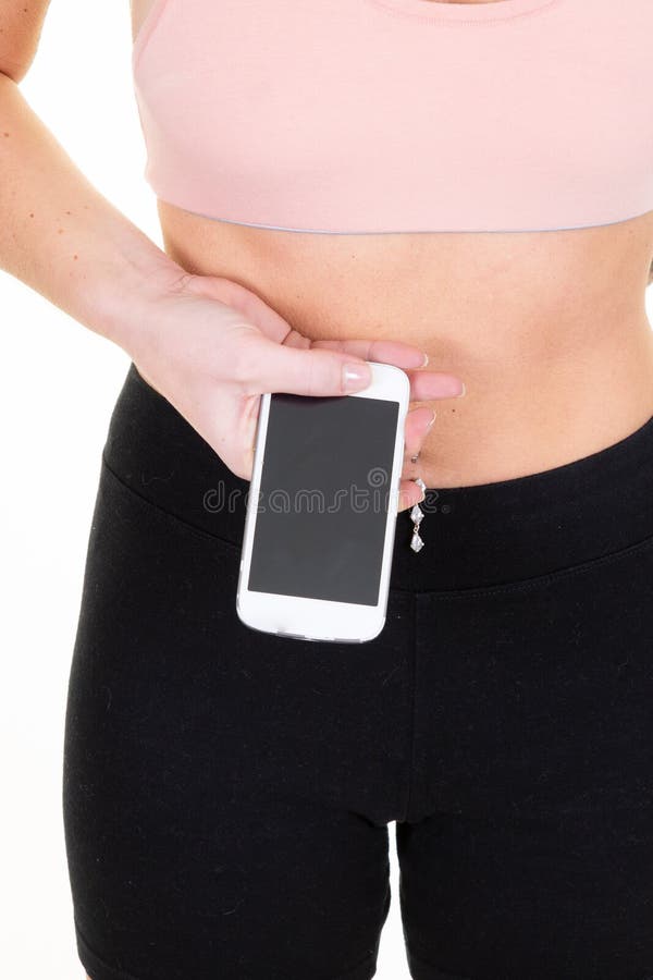 Mooie jonge, slanke sportvrouw maakt fitness-oefeningen geïsoleerd met behulp van een mobiele telefoon die een blanco scherm laat stock afbeeldingen Mooie jonge, slanke sportvrouw maakt fitness-oefeningen geïsoleerd met behulp van een mobiele telefoon die een blanco scherm laat stock afbeeldingen