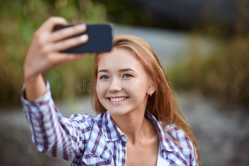 Mooie jonge vrouw die beeld van zich neemt Selfie op een vage natuurlijke achtergrond Gefiltreerd beeld royalty-vrije stock foto's Mooie jonge vrouw die beeld van zich neemt Selfie op een vage natuurlijke achtergrond Gefiltreerd beeld royalty-vrije stock foto's
