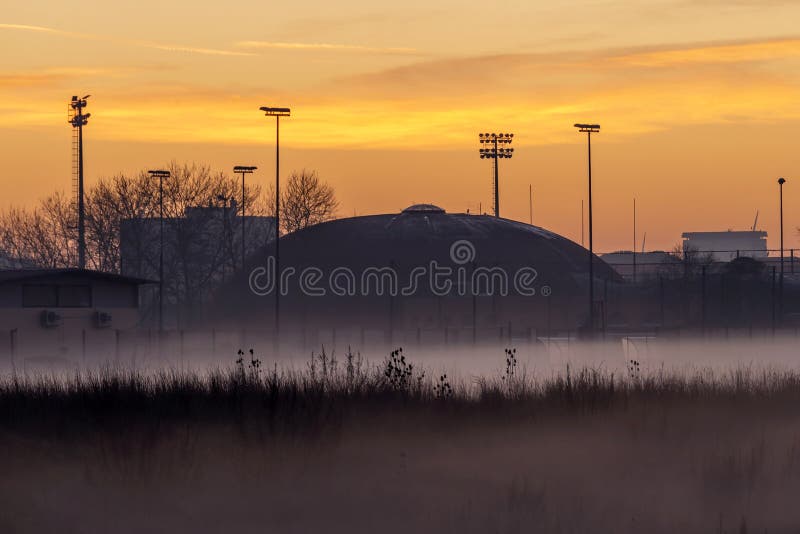 Mooie kijk op een stadswijk in mist, in het licht van de zonsondergang, Pontedera, Toscane, Italië stock fotografie Mooie kijk op een stadswijk in mist, in het licht van de zonsondergang, Pontedera, Toscane, Italië stock fotografie