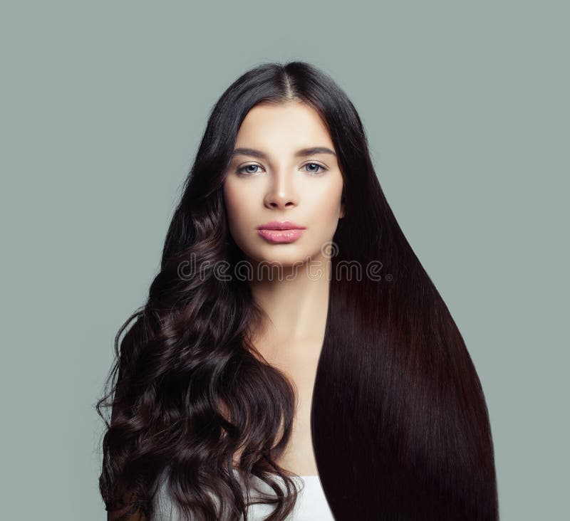Mooie mannequinvrouw met lang recht haar en perfect krullend kapsel op blauwe achtergrond stock fotografie Mooie mannequinvrouw met lang recht haar en perfect krullend kapsel op blauwe achtergrond stock fotografie