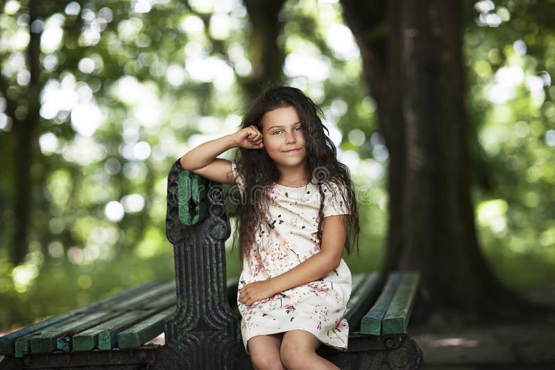 Mooie meisje het glimlachen zitting op banch in het park royalty-vrije stock afbeelding Mooie meisje het glimlachen zitting op banch in het park royalty-vrije stock afbeelding