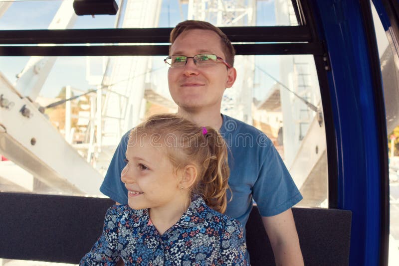 Mooie mensen met zijn vrij gelukkige dochterzitting in ferris w stock foto Mooie mensen met zijn vrij gelukkige dochterzitting in ferris w stock foto