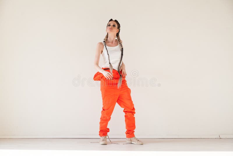 Mooie modieuze vrouw met overall van het vlechten de dansende werk stock fotografie Mooie modieuze vrouw met overall van het vlechten de dansende werk stock fotografie
