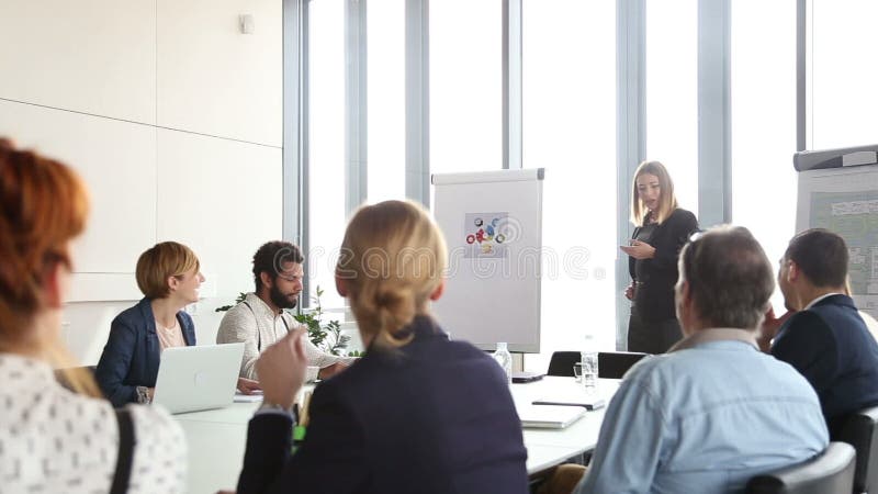 Mooie onderneemster die presentatie geven aan collega's die flipchart gebruiken