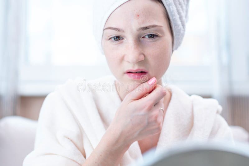 Mooie ongelukkige jonge vrouw die acne op haar gezicht bekijken Concept hygiëne en zorg voor de huid stock foto's Mooie ongelukkige jonge vrouw die acne op haar gezicht bekijken Concept hygiëne en zorg voor de huid stock foto's