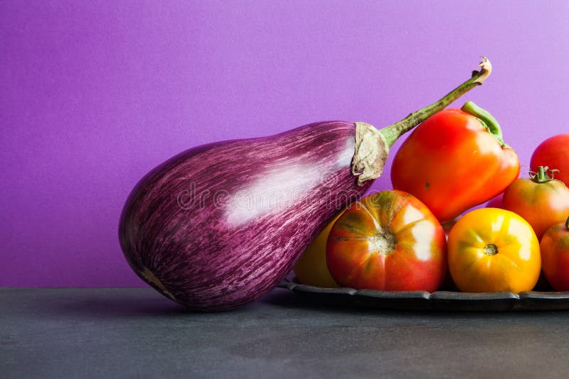 Mooie organische violette aubergine en verse groentenoogst op een uitstekend dienblad Rijpe groene paprika, gele rode tomaten stock afbeeldingen Mooie organische violette aubergine en verse groentenoogst op een uitstekend dienblad Rijpe groene paprika, gele rode tomaten stock afbeeldingen