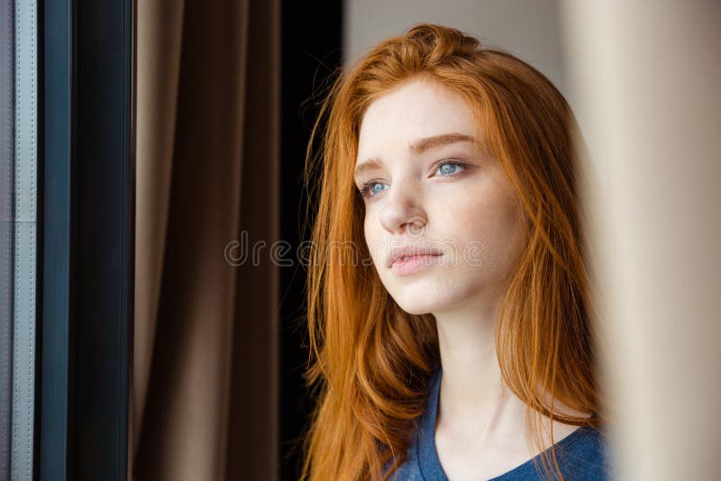 Closeup of young beautiful tender pensive woman with long red hair looking away and dreaming. Closeup of young beautiful tender pensive woman with long red hair looking away and dreaming